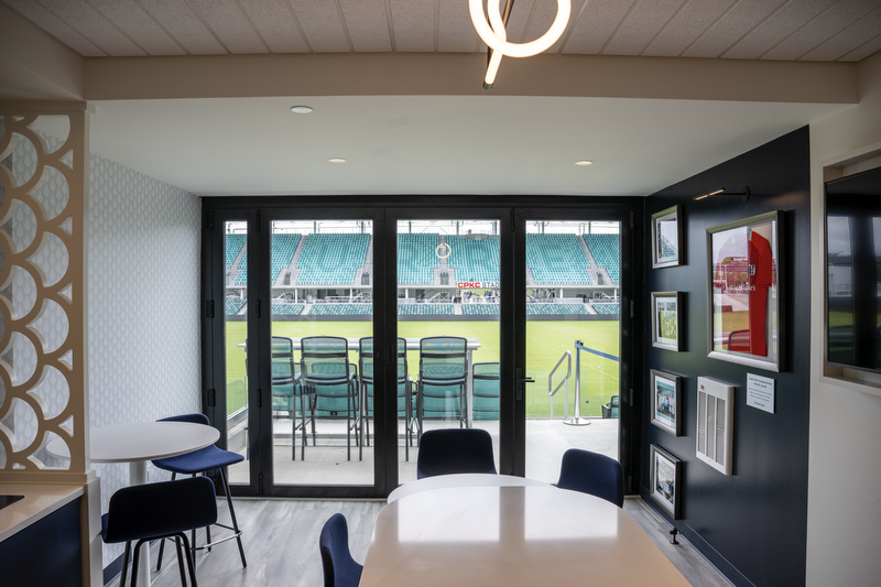 A view of inside a suite of doors looking out to the pitch and their suites seating.