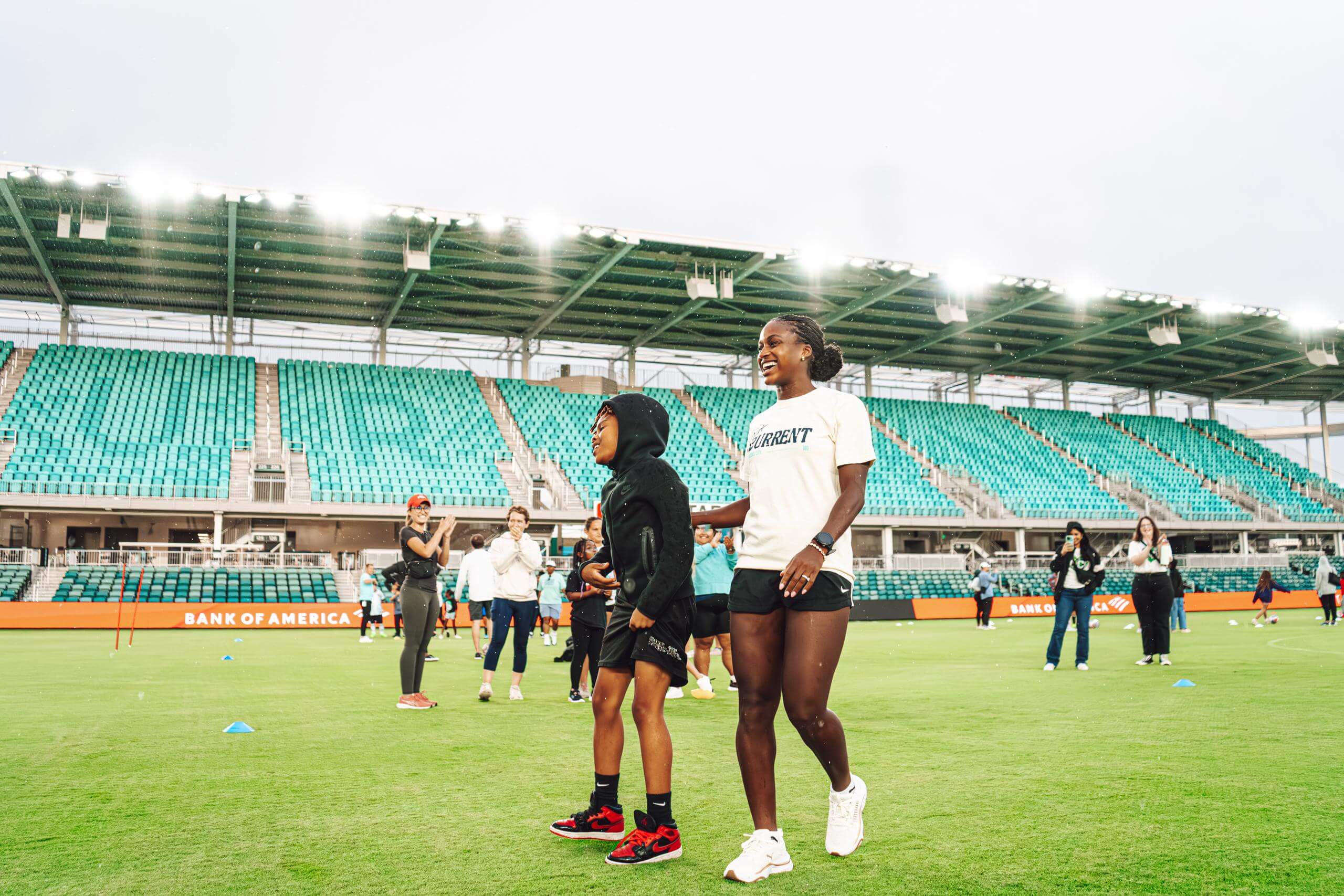 A image showing Nichelle Prince playing soccer with kids and the Bank of America Youth Clinic.