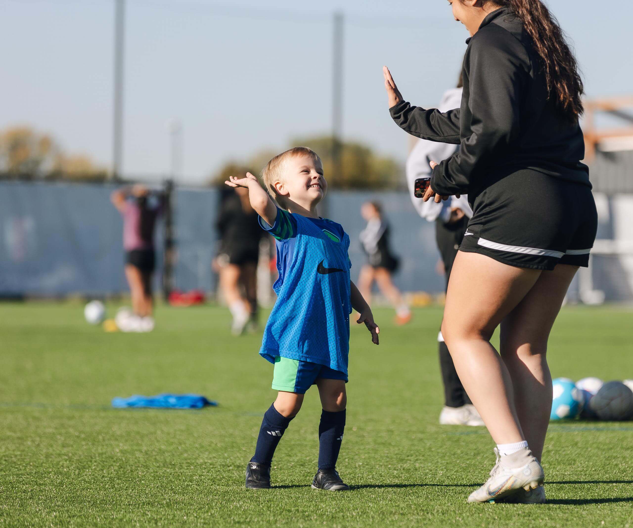 Boy gives high five at HyVee Soccer Clinic. 