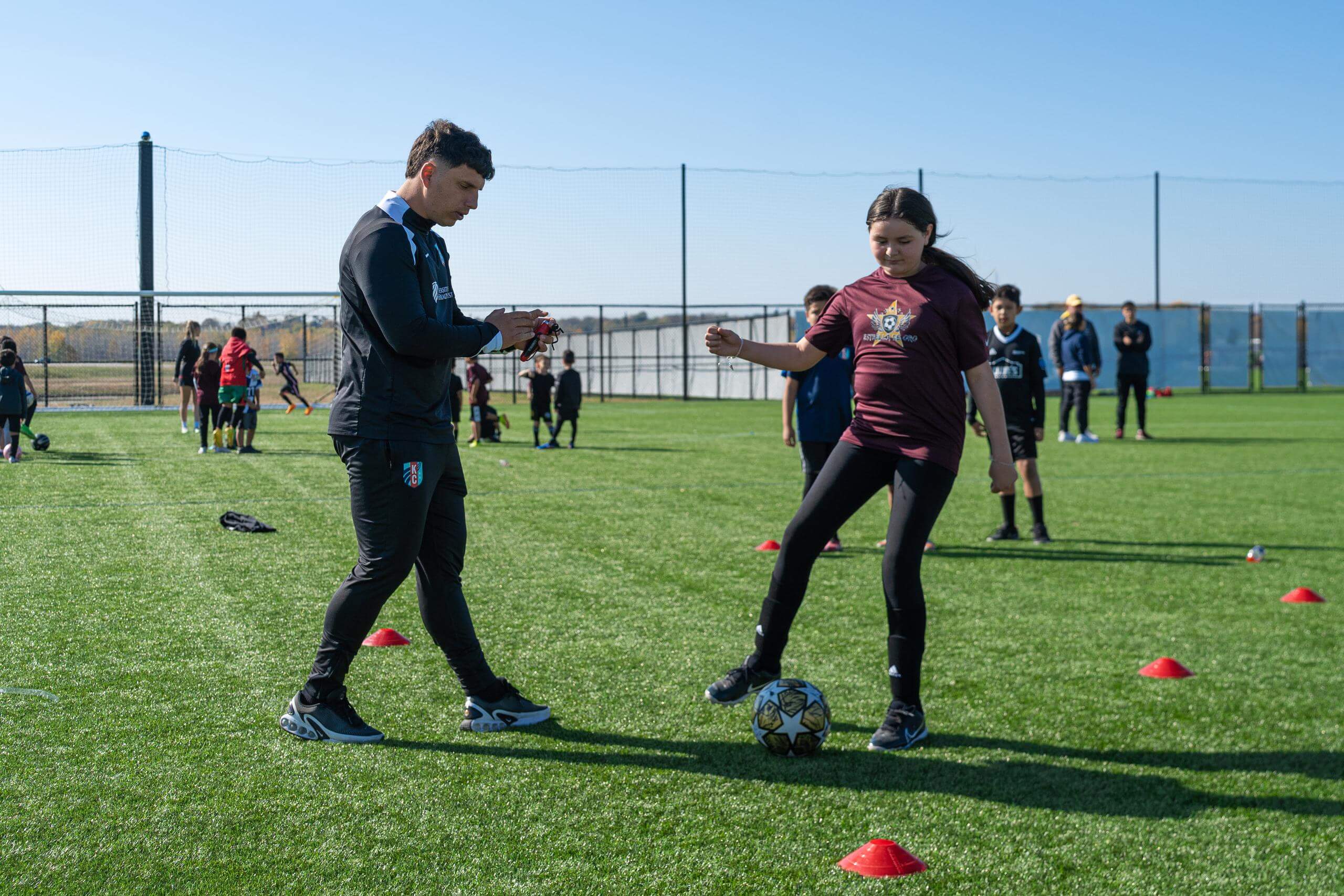 Player from EDO being coached by KC Current coach at Bank of America Clinic.