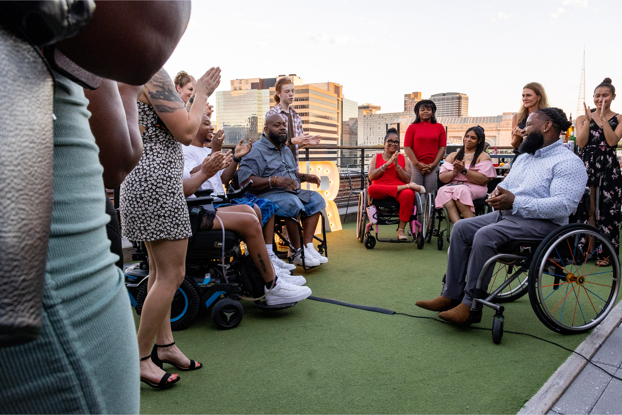 An image of an event where individuals are gathered in a circle on a rooftop patio.